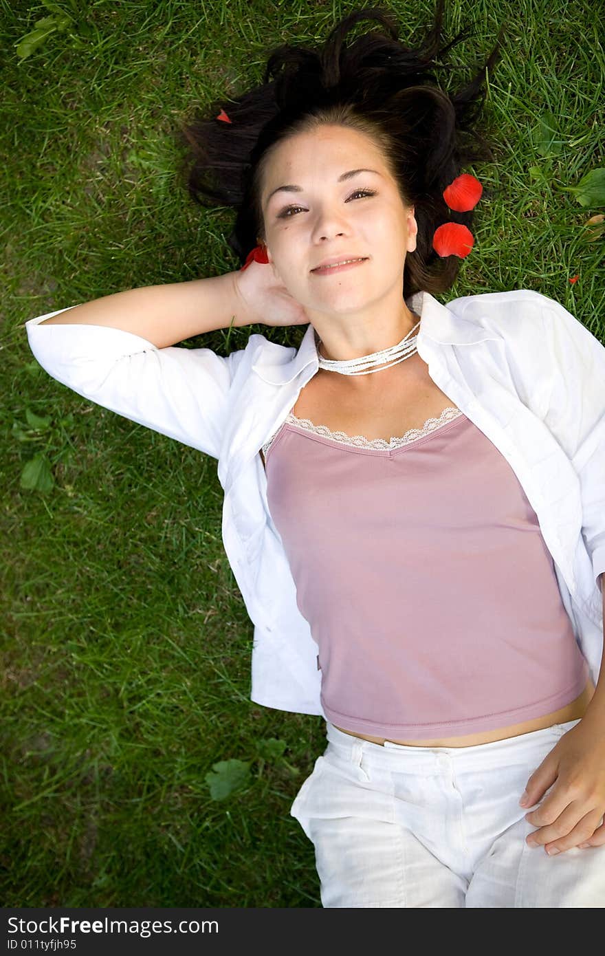 Happy brunette woman lying on grass. Happy brunette woman lying on grass