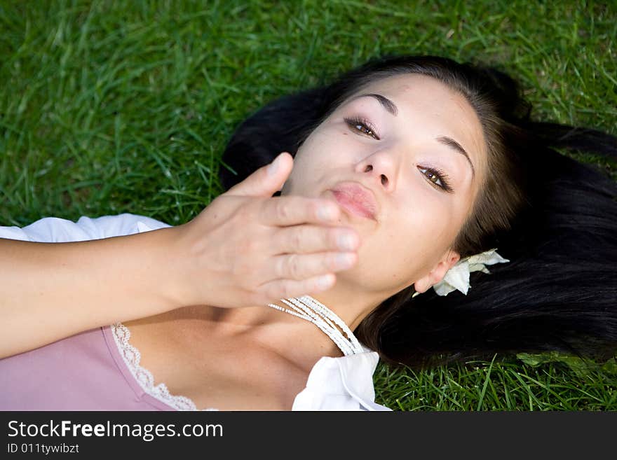 Happy brunette woman lying on grass. Happy brunette woman lying on grass