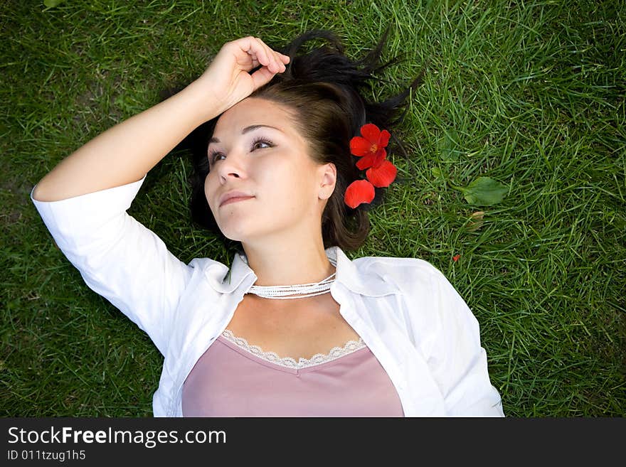 Happy brunette woman lying on grass. Happy brunette woman lying on grass