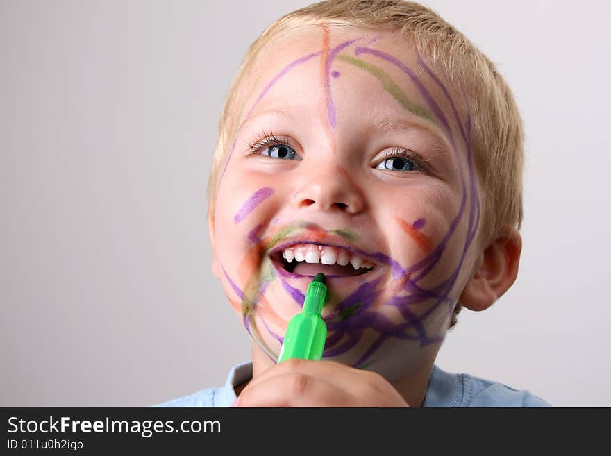 Laughing Toddler playing with colored pens making a mess