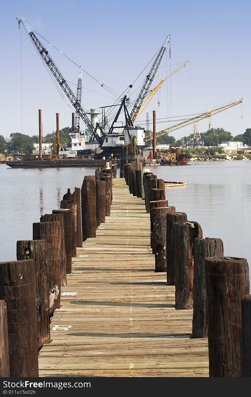 A pier view of floating cranes on the water