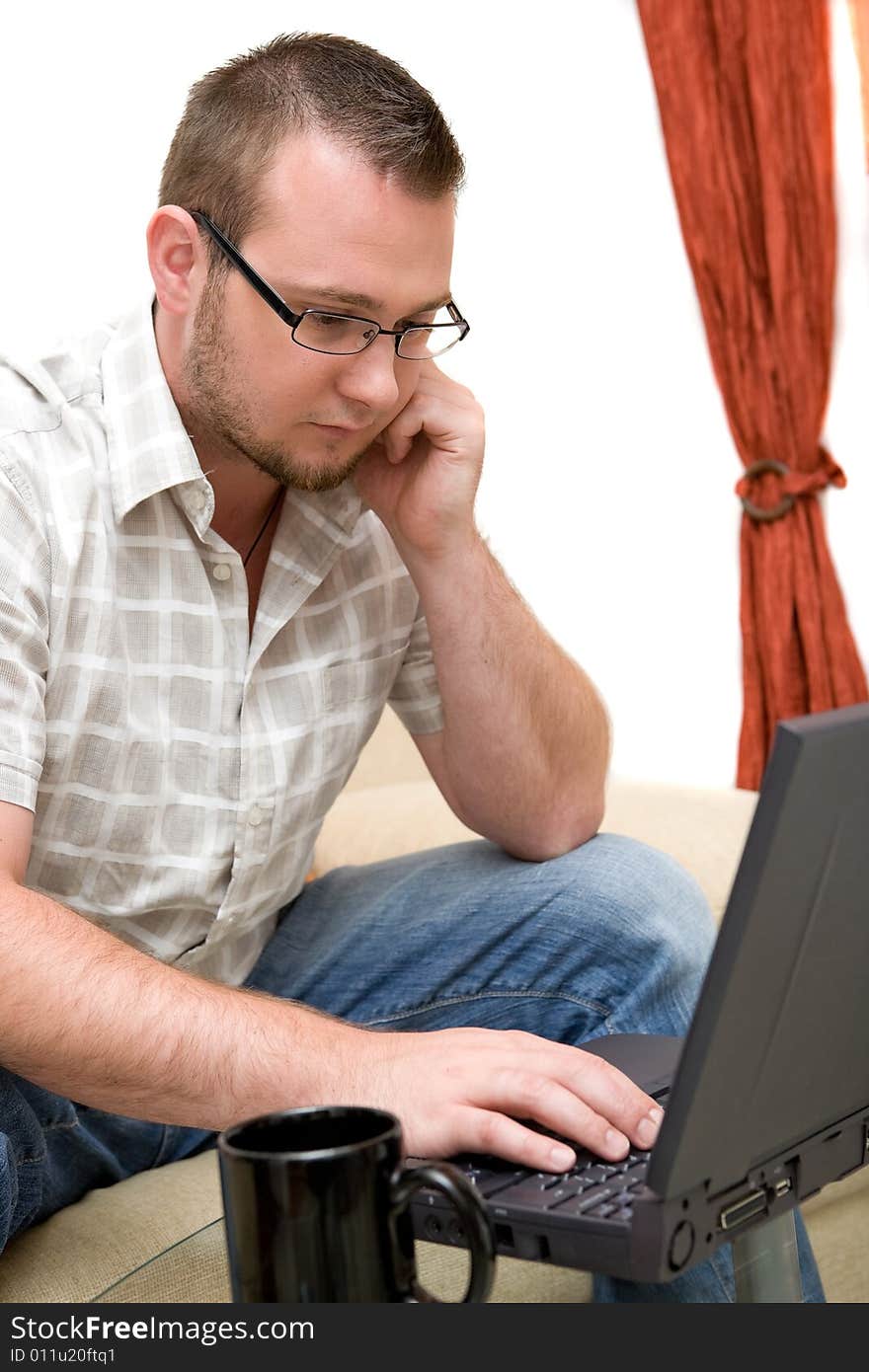 Casual man sitting on sofa with laptop. Casual man sitting on sofa with laptop