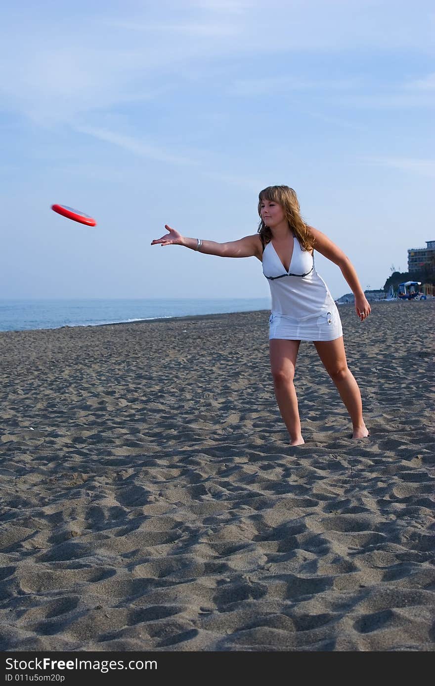 Joyful girl play on coast of ocean