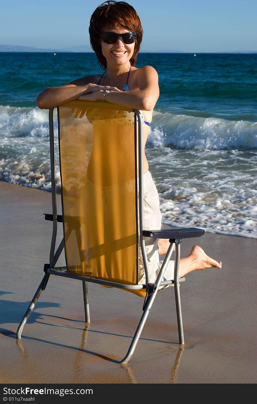 Young beautiful woman has a rest on coast of ocean