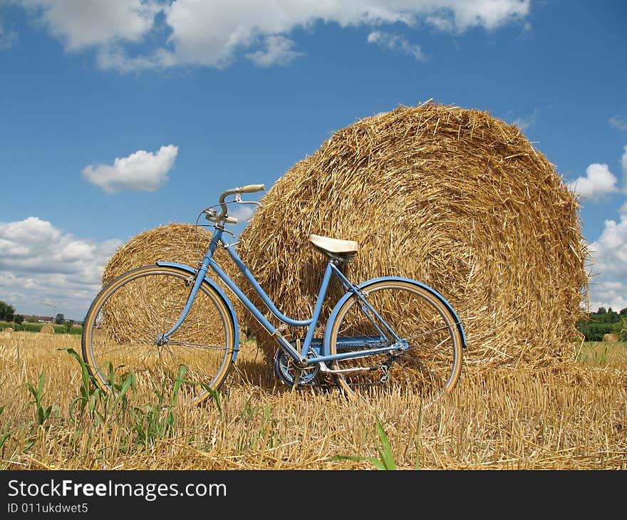 Classic bike, hay bales with blue sky and white clouds. Classic bike, hay bales with blue sky and white clouds