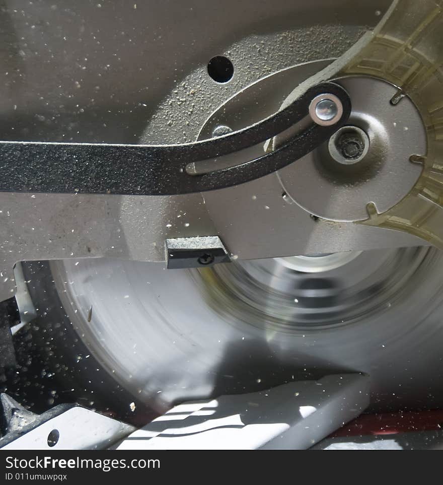 A closeup of a power saw sawing white wood. A closeup of a power saw sawing white wood.