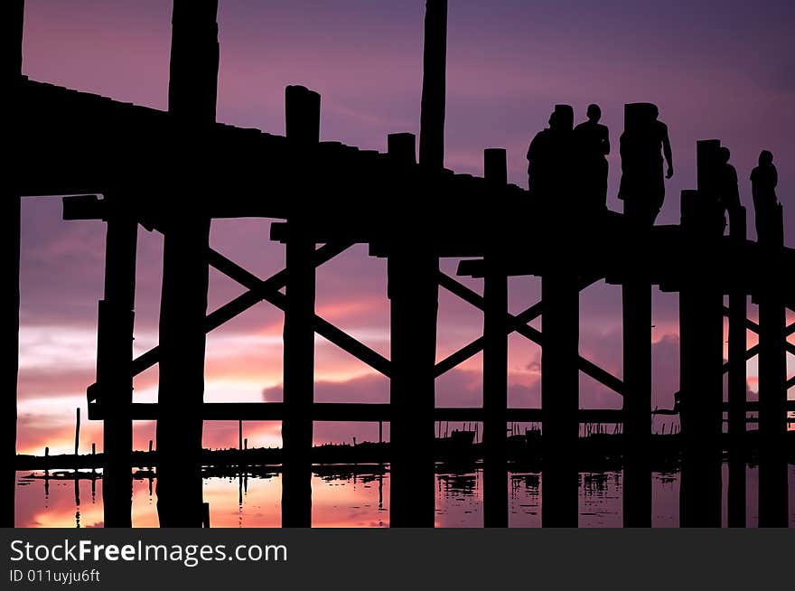 Myanmar, Amarapura, U Bein bridge; stunning sundown at the U bein bridge; bicycle and men black silhouettes