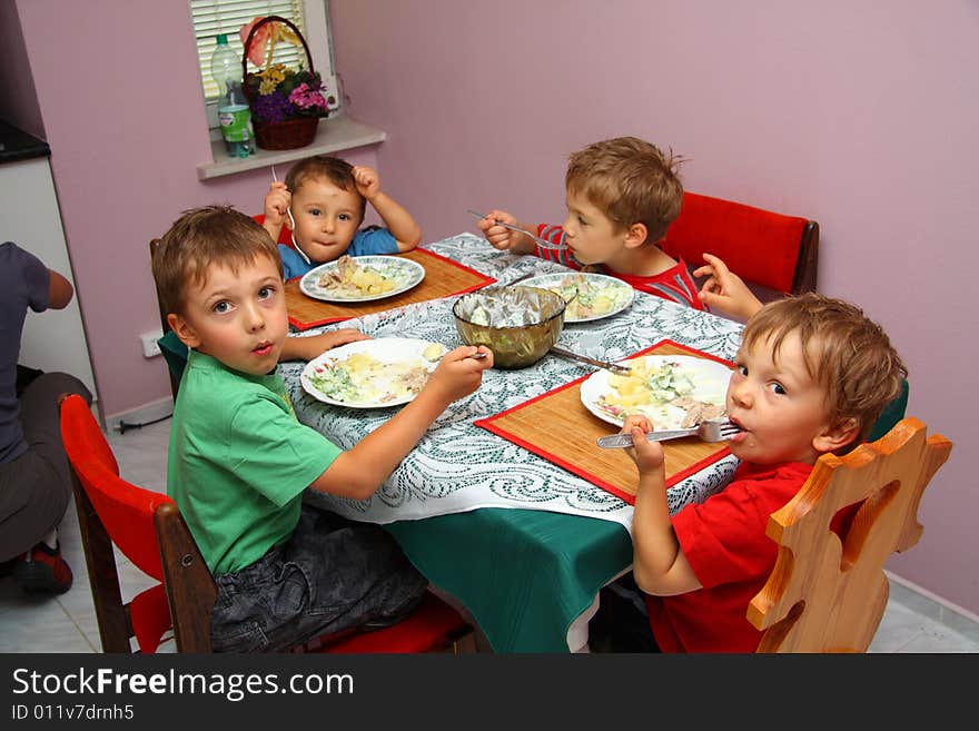 Young boys indoors eating