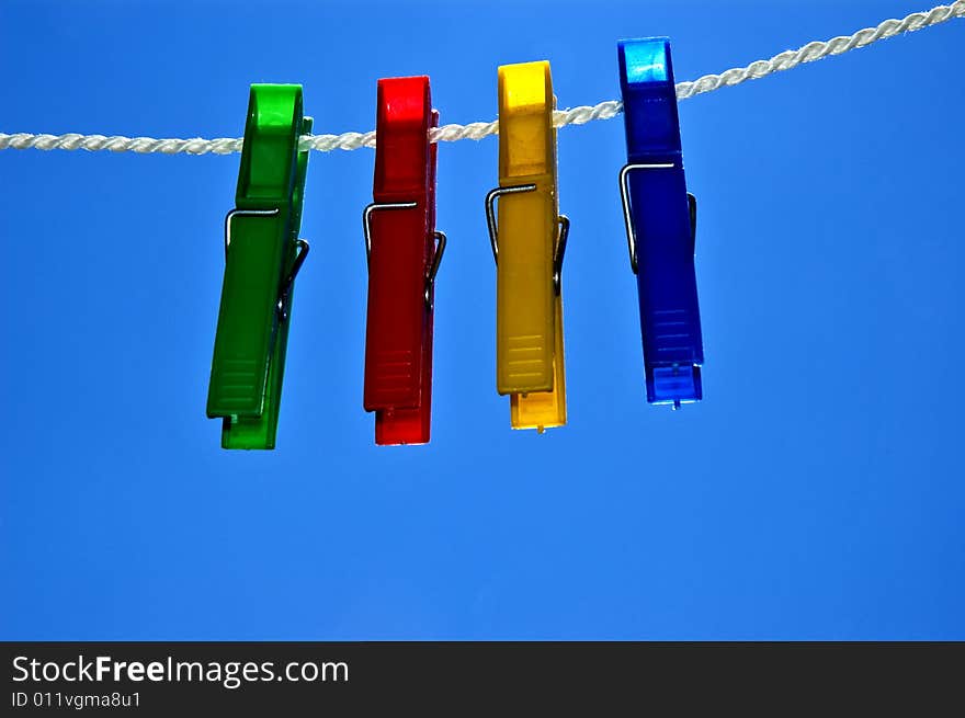 Green, red, yellow and blue clips on rope.