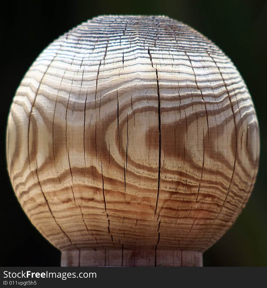 Close view of a grained wood fence post on a dark background. Close view of a grained wood fence post on a dark background