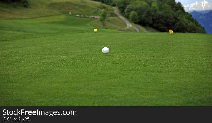 Close view of a golf tee in front of a mountain scenery