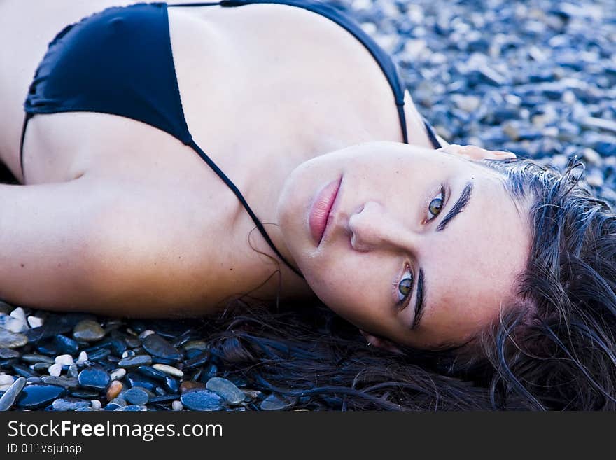 Laying beauty wearing black small bikini.