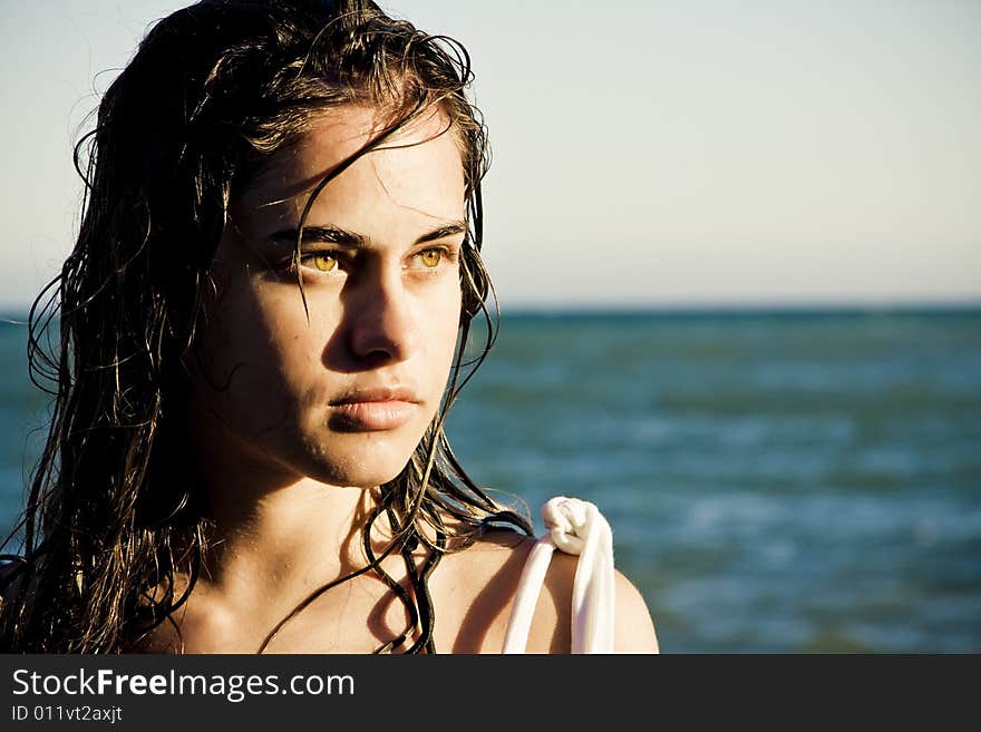 Beautiful green eyed woman portrait with the sea as background. Beautiful green eyed woman portrait with the sea as background.