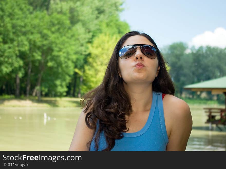 Pretty girl sending kiss near a lake