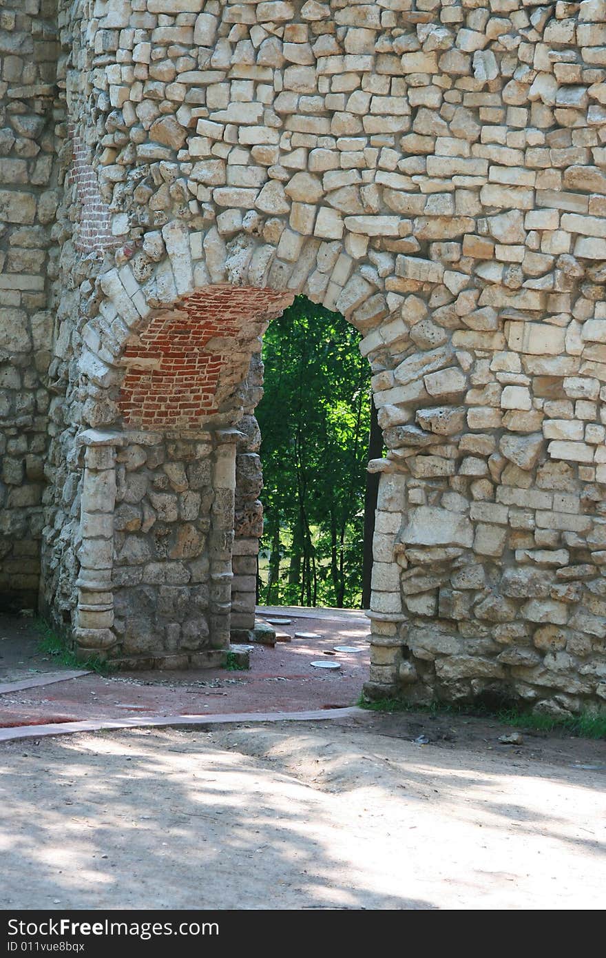 Old stone wall with an arch pass inside