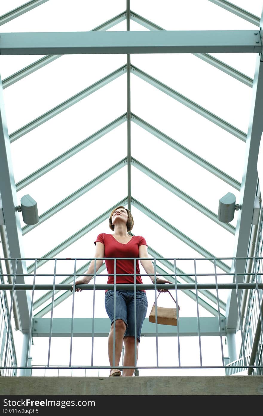 Woman standing on urban balcony looking around. Woman standing on urban balcony looking around.