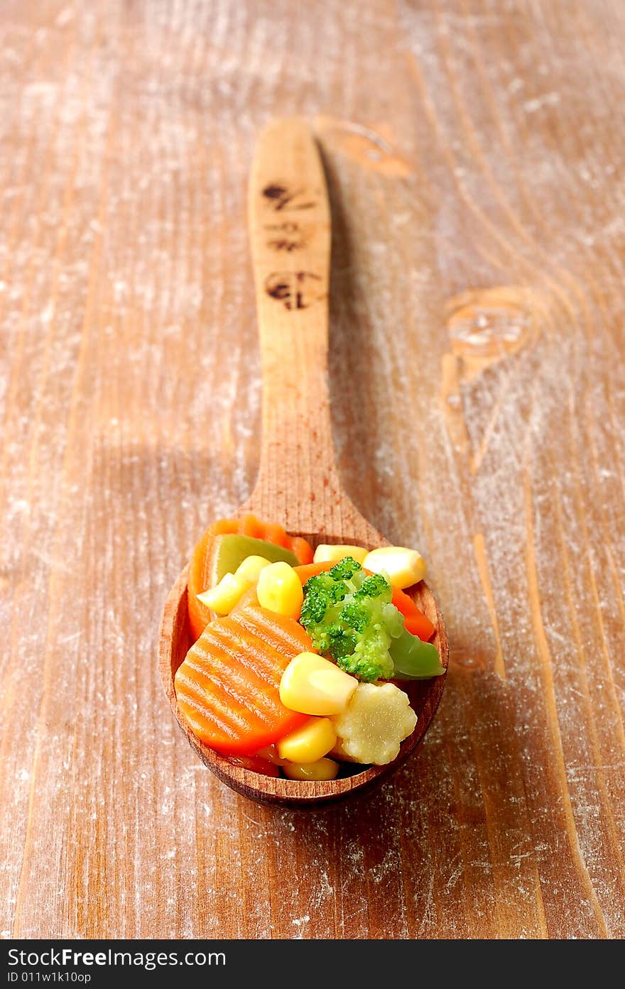 Vegetablesi on a wooden spoon