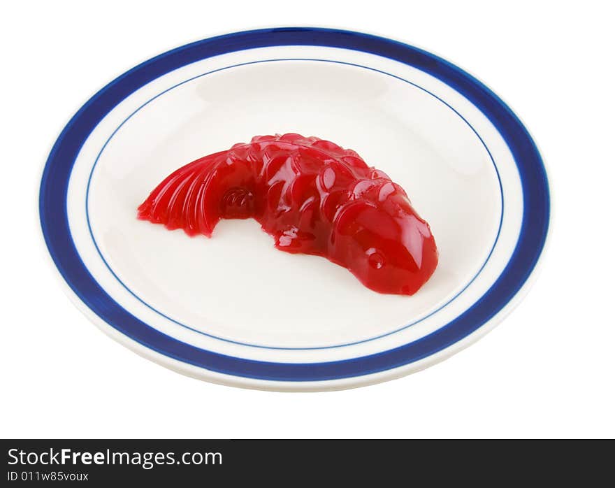 Red fish shaped jello on a plate, isolated in solid white background. Red fish shaped jello on a plate, isolated in solid white background.