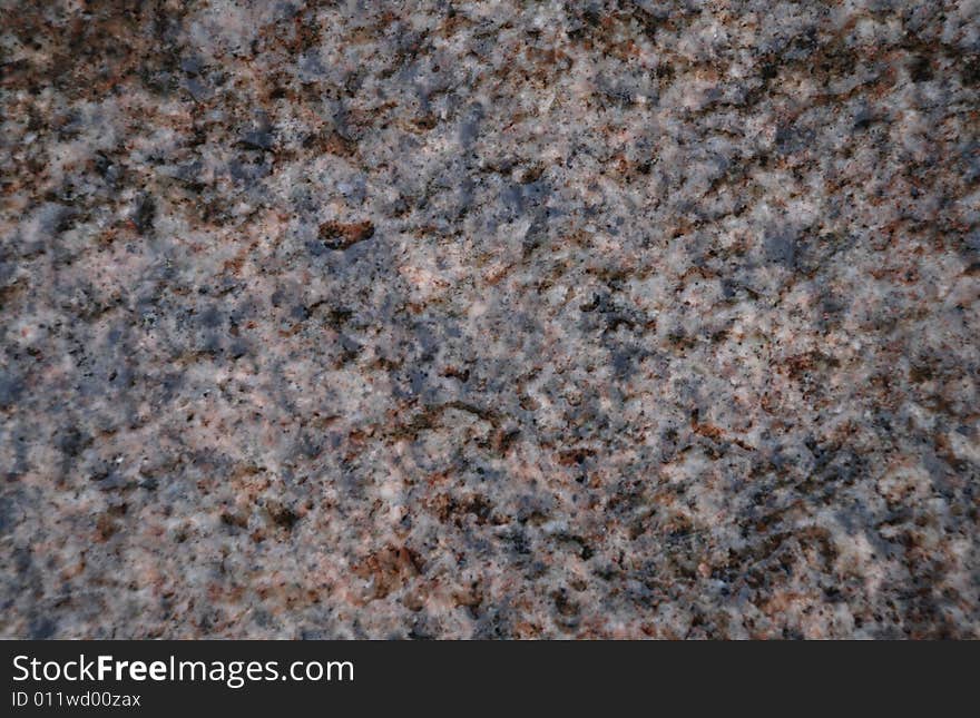 Wet stone texture with grey, black and pink inclusions