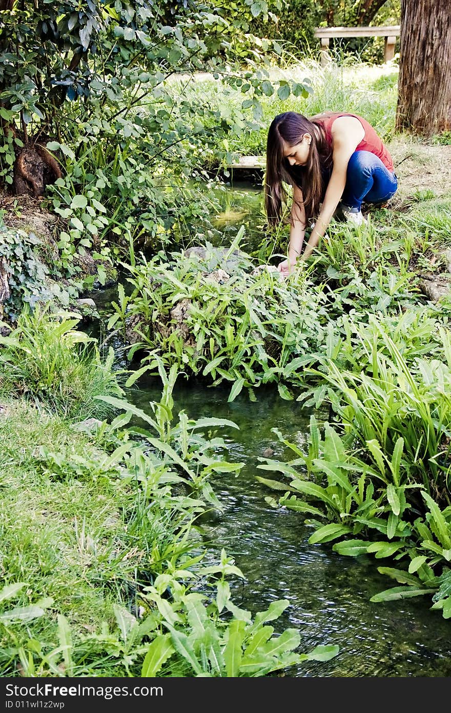 Young woman taking fresh water from river. Young woman taking fresh water from river.