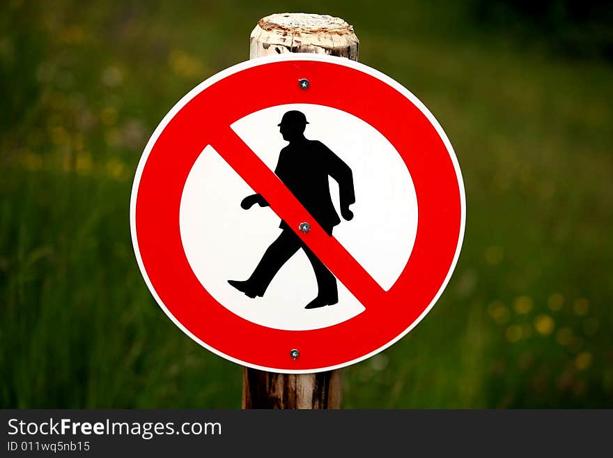 Sign showing no passage for people fixed on a wooden post. Sign showing no passage for people fixed on a wooden post