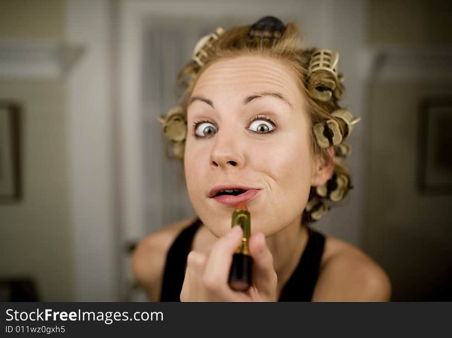 Woman in Curlers Applying Bright Red Lipstick. Woman in Curlers Applying Bright Red Lipstick