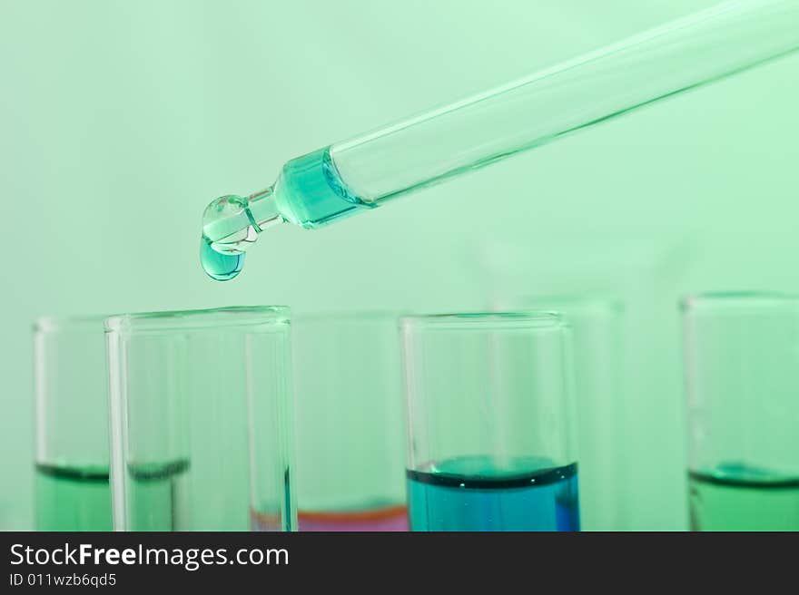 Blue drop from a pipette in a science lab