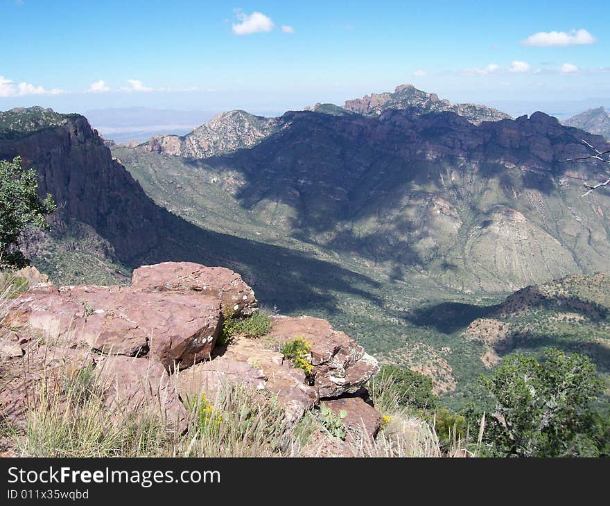 Desert mountain vista with rocks in foreground and cloud shadows