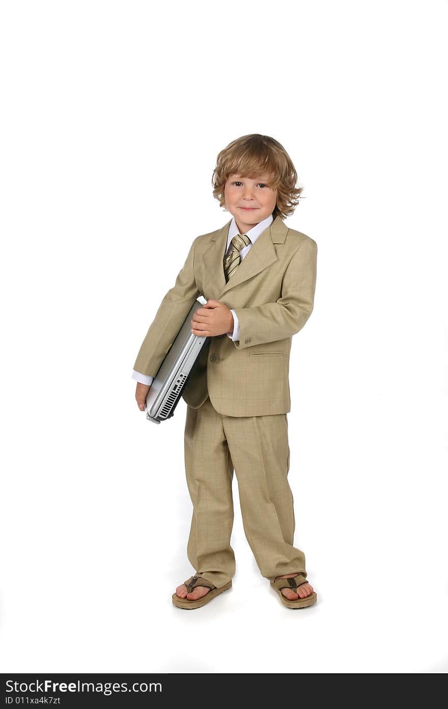 Young boy in tan suit holding laptop under his arm. Young boy in tan suit holding laptop under his arm