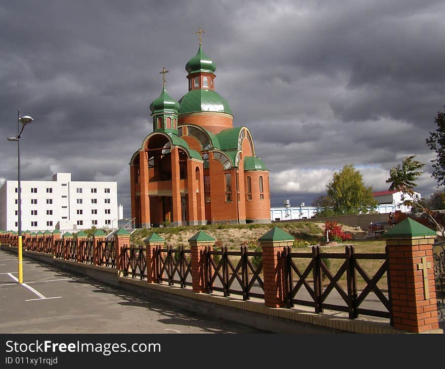 Orthodox church in the city of Brovary, Ukraine. The sky in dark clouds and only above church shines the sun.