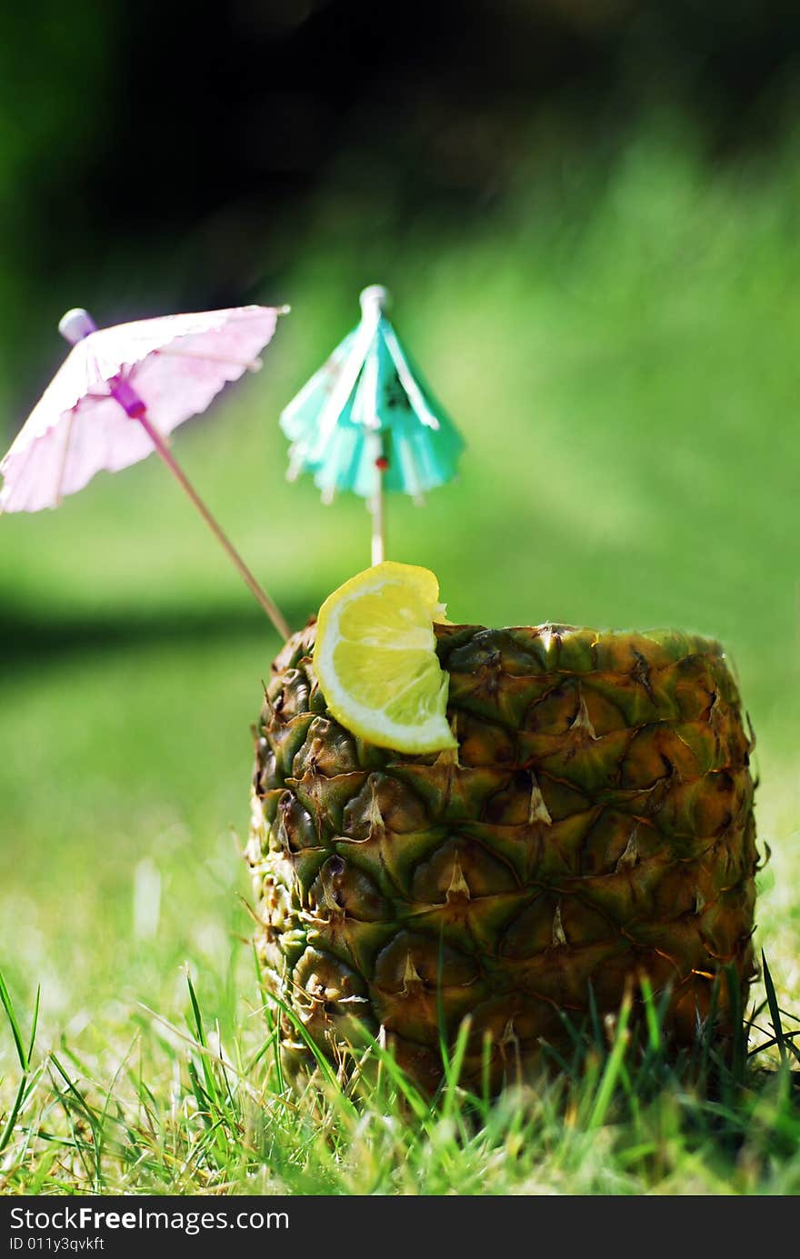 Natural Pineapple hollowed out and filled with an icy drink and tropical umbrellas. Natural Pineapple hollowed out and filled with an icy drink and tropical umbrellas