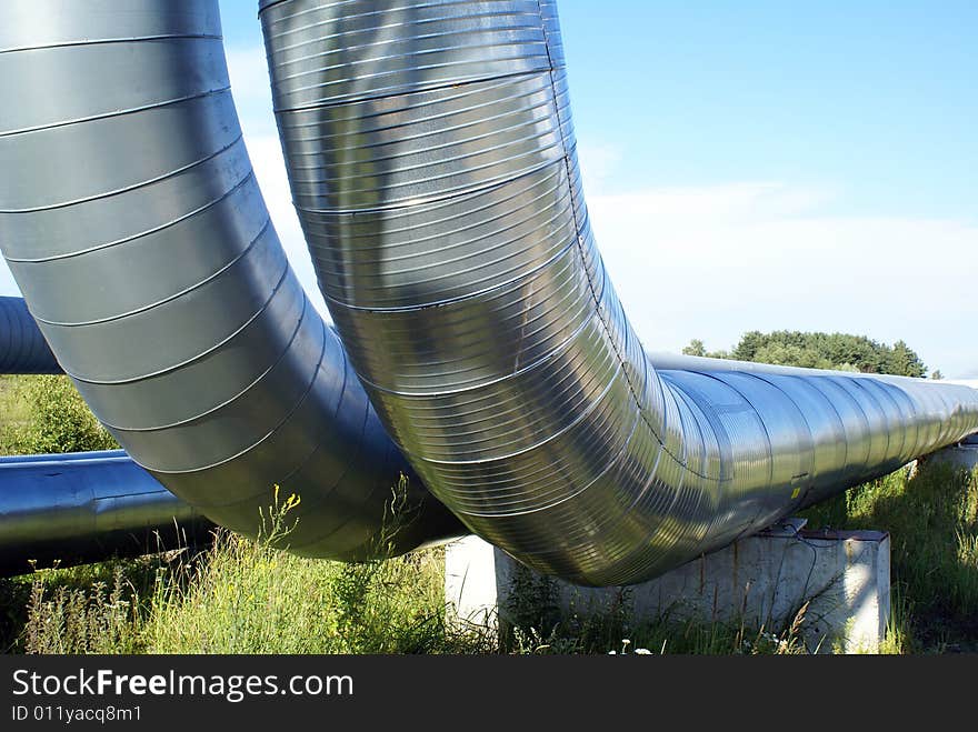 Industrial pipelines on pipe-bridge and electric power lines  against blue sky. Industrial pipelines on pipe-bridge and electric power lines  against blue sky