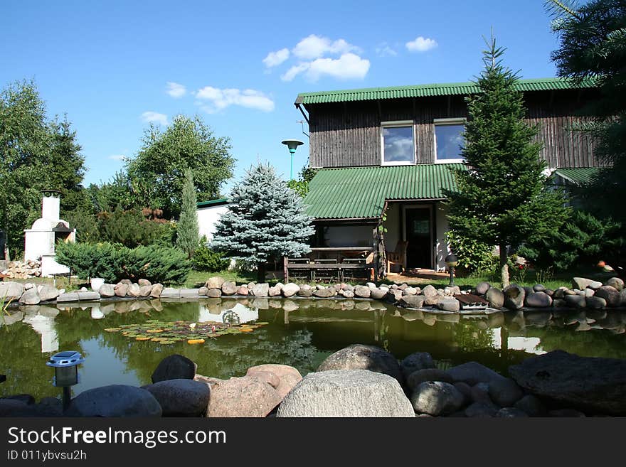 Holiday house in village with lake over blue sky