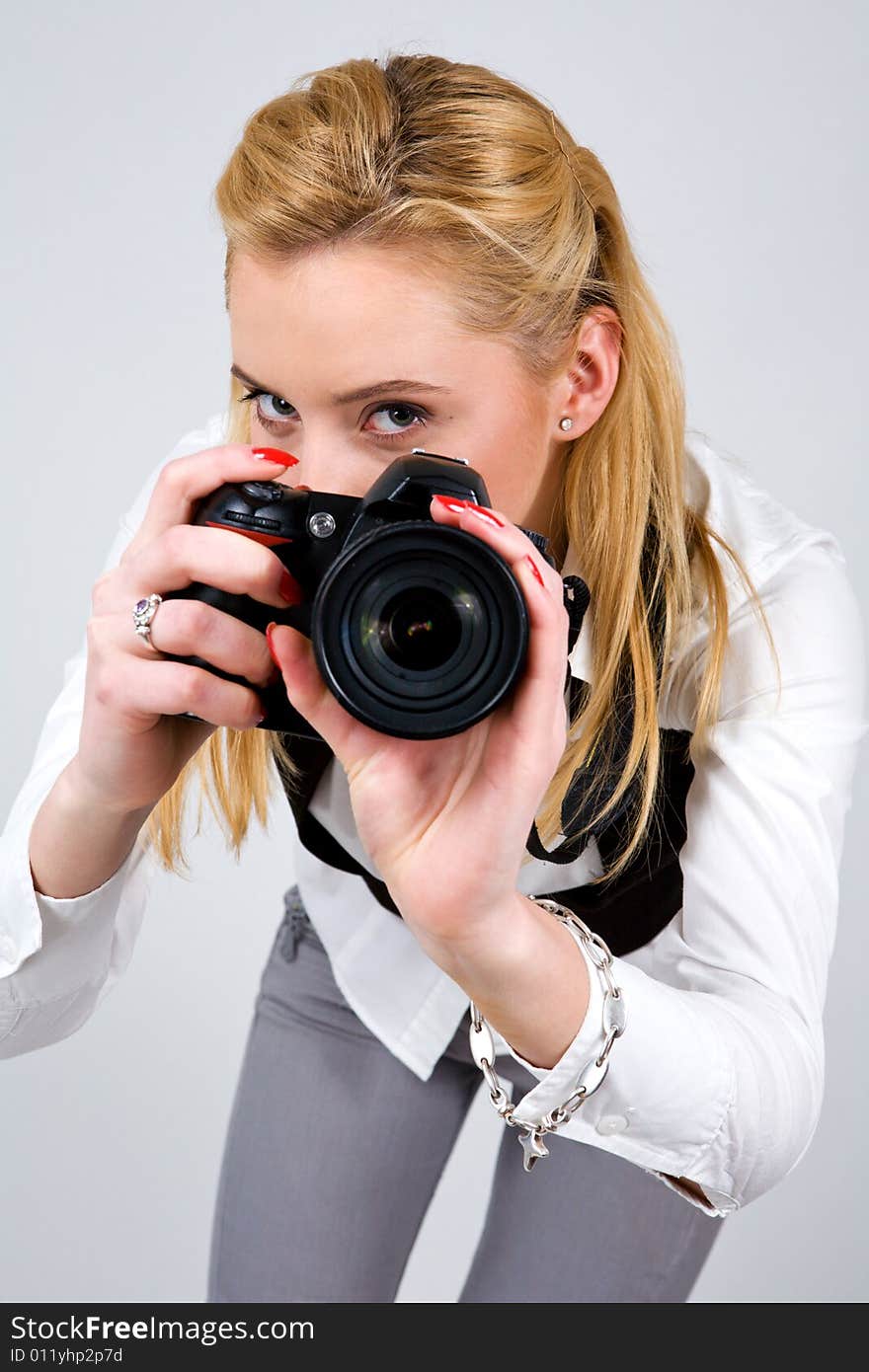 Young blond woman holding camera in studio. Young blond woman holding camera in studio