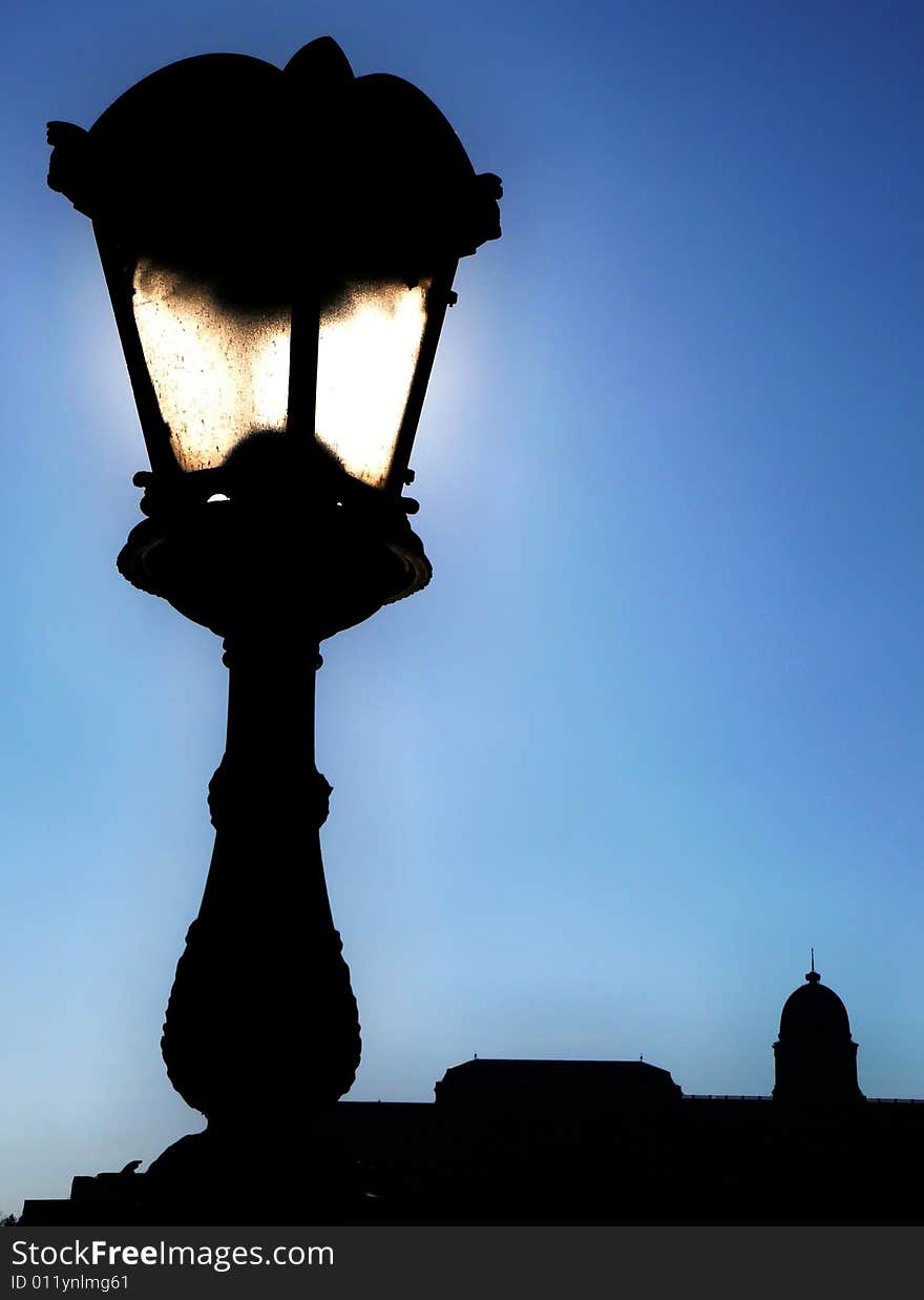 The image shows a lantern with a castle in the background. The image shows a lantern with a castle in the background.