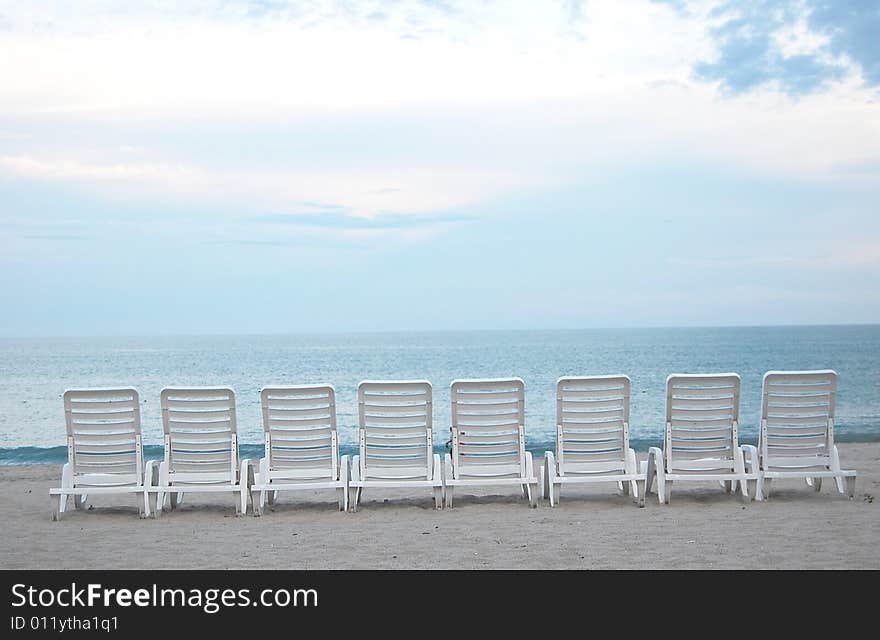 Row of chairs at a bech facing the ocean. Row of chairs at a bech facing the ocean