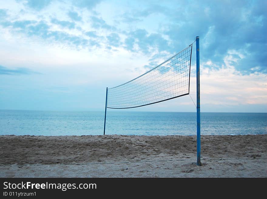 Volleyball net at a lonely beach with blue sky in the background