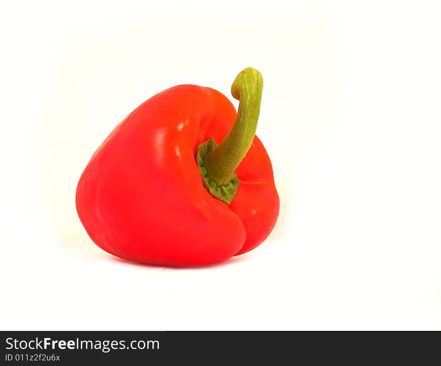 A red sweet pepper on a white background. Shot taken from 2/3 perspective