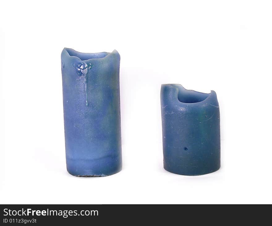 2 blue candles on a white background. Candles are a little melted on the top.