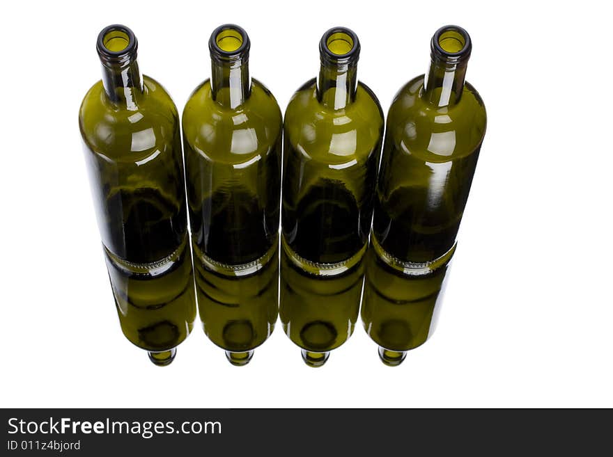 Four wine bottles on a mirror