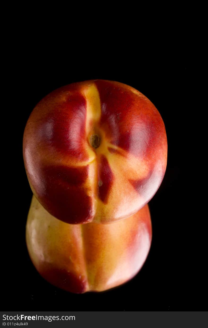 Single nectarine on a mirror