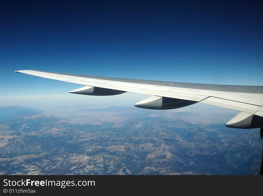 Jet wing soaring over a mountain range. Jet wing soaring over a mountain range.