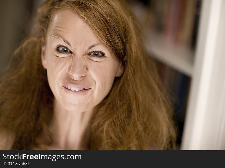 Woman with big hair scrunching her face to make a funny expression. Woman with big hair scrunching her face to make a funny expression