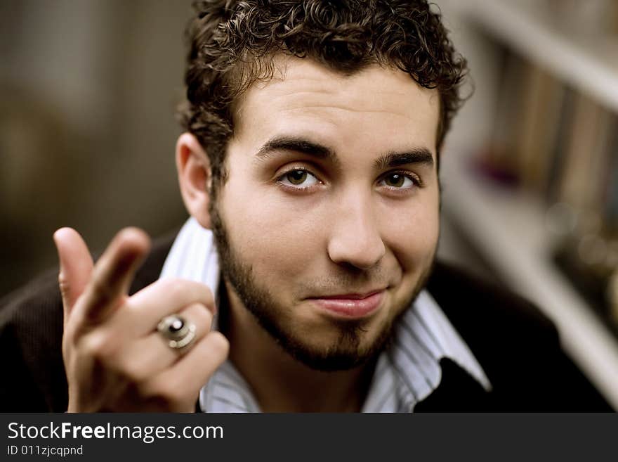 Portrait of handsome young man with beard gesturing with his hand