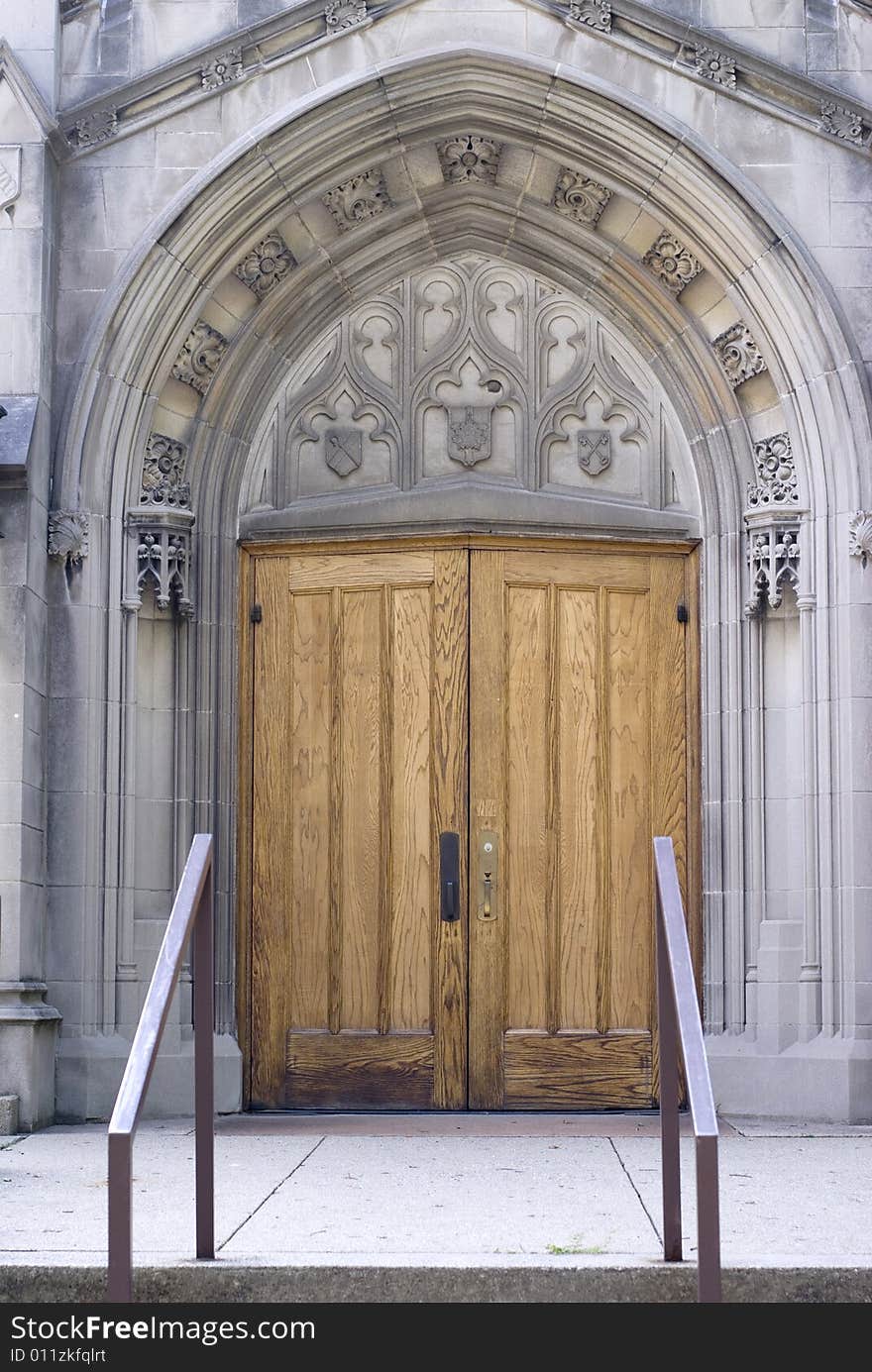 An ornate arch ensconcing a heavy wooden church door. An ornate arch ensconcing a heavy wooden church door.