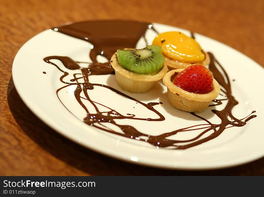 Fruit Tarts With Chocolate Drizzled On Plate