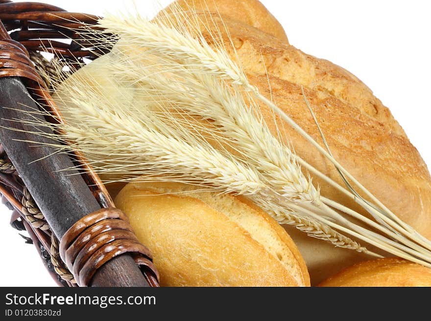 Basket of wheat bread, buns and wheat ears. Basket of wheat bread, buns and wheat ears.