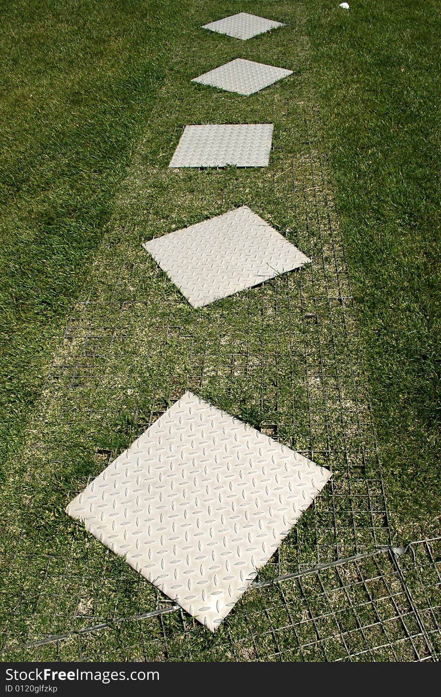 Metal square way in grass