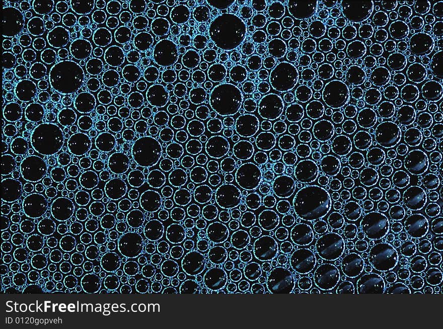 Layer of blue soap bubbles with black background. Layer of blue soap bubbles with black background