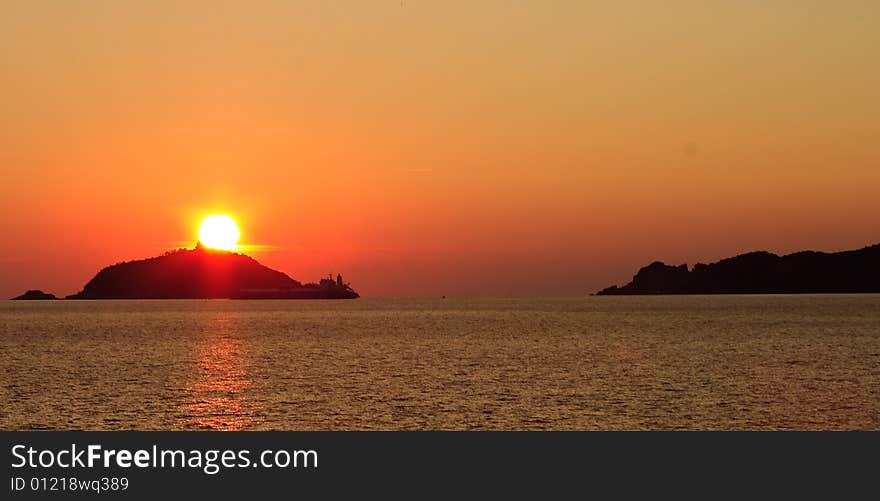 Sunrise over the sea through low clouds